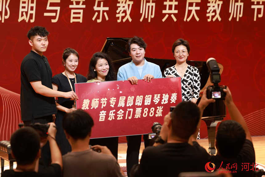 郎朗为教师代表赠送了音乐会门票。 人民网记者 李兆民摄